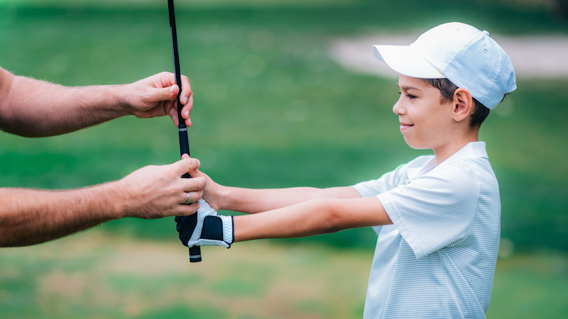 niño en lección de golf