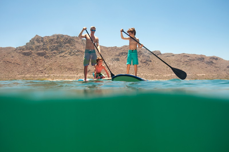 Familia practicando paddle board en Loreto