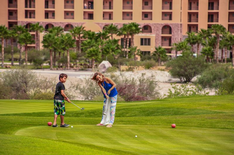 family playing the putting course at tpc danzante bay